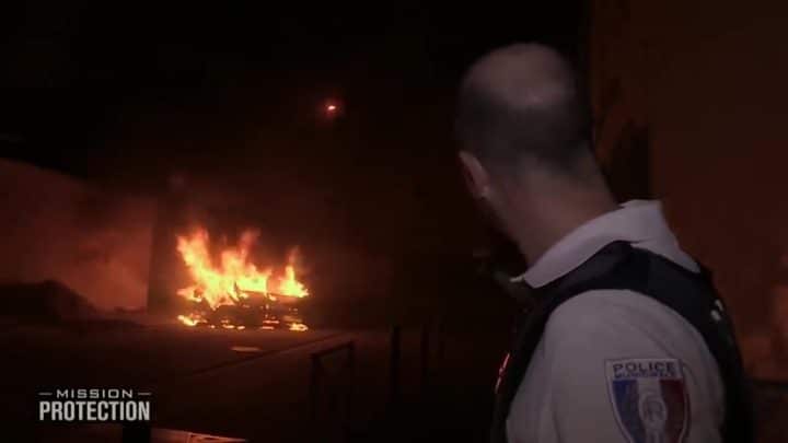 , police municipale; Un véhicule est englouti par les flammes sur un boulevard, incitant un agent de